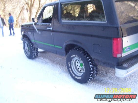 1993 Ford Bronco in snow, rear quarter view. Green stripe on side