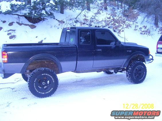 Black Ford Ranger pickup truck with lifted suspension and off-road tires in the snow