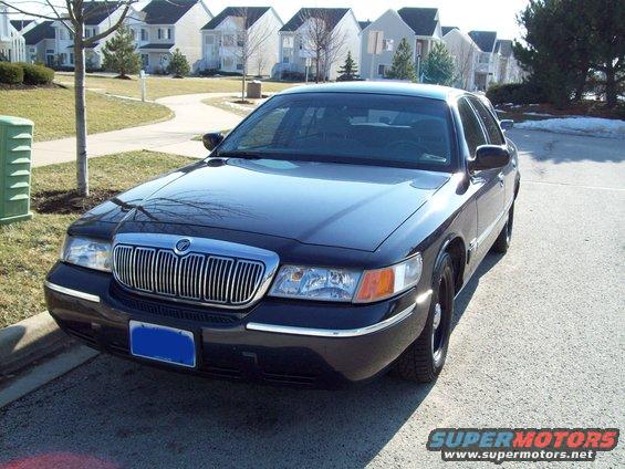 Dark Mercury Grand Marquis parked in a suburban setting.
