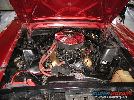 Red 1972 Ford Ranchero engine bay with a V8 engine, chrome accents, and orange hoses