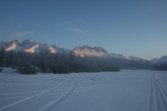 Snowy landscape with mountains under a clear blue sky