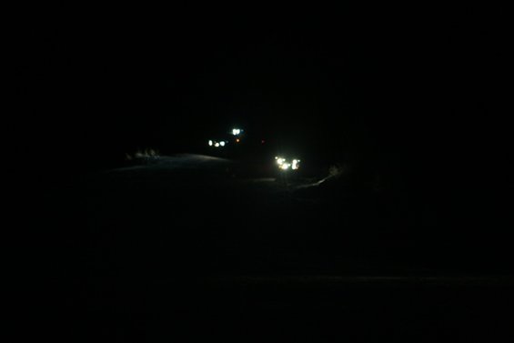 Headlights of a vehicle shine in the dark
