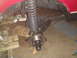 1992 Ford Bronco - Close-up view of a vehicle's front suspension system, showing the coil spring, shock absorber, and brake rotor.