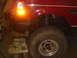 1992 Ford Bronco - Close-up of a 1992 Ford Bronco's side, highlighting the fender, large tire, and suspension.