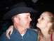 1996 Ford Bronco - A couple shares an intimate moment at a party, with one wearing a cowboy hat and the other looking on.
