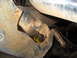 1978 Ford Bronco - A close-up view of a rusty suspension component with a yellow bushing visible.