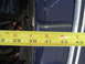 1978 Ford Bronco - A yellow measuring tape is placed against a dark blue vehicle panel, showing measurements in inches.