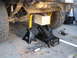 1978 Ford Bronco - The underside of a vehicle is supported by jack stands and a floor jack, with tools nearby.