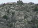 2006 Ford E350 - A rocky hillside landscape with sparse vegetation under an overcast sky.