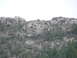 2006 Ford E350 - A natural landscape a rocky incline dotted with evergreen trees and low-lying brush.