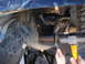 1978 Ford Bronco - Mechanic works on a vehicle's suspension system, focusing on a specific part.