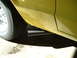 1978 Ford Ranchero - A close-up view of a yellow vehicle's side, showing the exhaust pipe and a portion of the wheel.