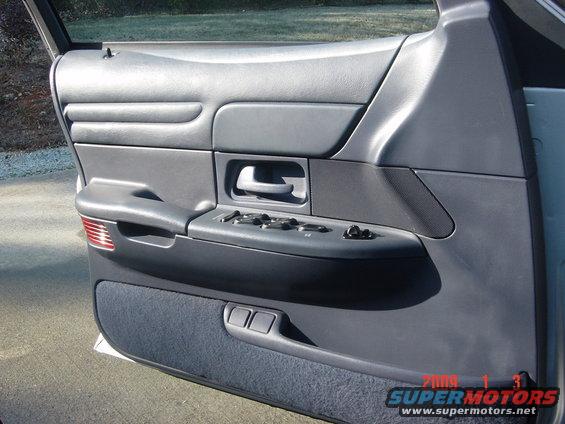 Gray car door panel with power window controls and fabric insert