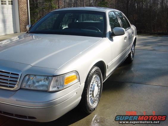 Silver 2000 Ford Crown Victoria sedan parked on a wet driveway