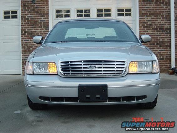 Silver Ford Crown Victoria front view, parked in front of a garage