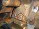 1978 Ford Bronco - The heavily rusted frame components of a vehicle are visible, supported by wooden blocks for maintenance.