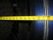 1978 Ford Bronco - A measuring tape is used to assess the clearance of a large tire against a blue vehicle body panel.