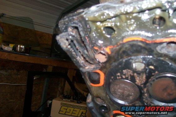 Close-up of a damaged engine cylinder head with a blown gasket