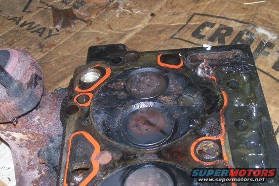 Engine cylinder head with orange gasket material and visible valves