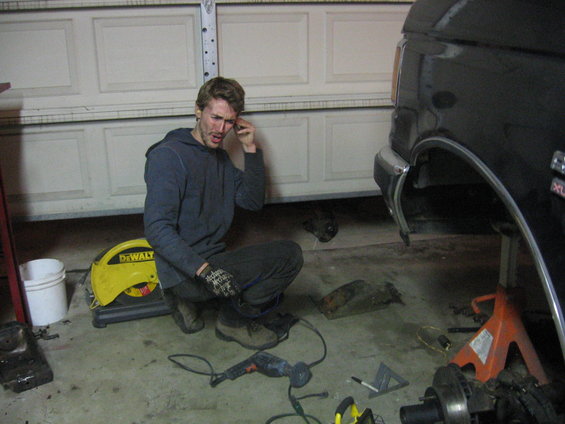 Side view of a black 1989 Ford Bronco being worked on in a garage