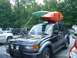 1997 Toyota Land Cruiser - SUV with kayaks on roof rack parked in a lot with other vehicles.