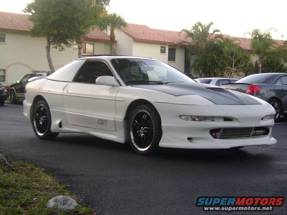 White Ford Probe with a custom hood and body kit, parked outside