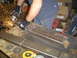1979 Ford Bronco - Grinding metal tubing on a workbench with sparks flying.