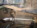 1989 Ford Bronco - Close-up of a vehicle's aftermarket exhaust system, a polished metal muffler and tailpipe.