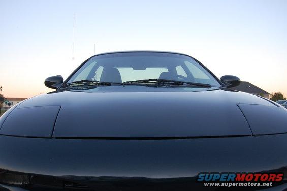 Front view of a dark coupe with pop-up headlights closed.