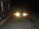 1994 Ford Crown Victoria - A red sedan is parked in a driveway at night, its headlights illuminating the scene.