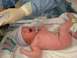 1994 Ford Crown Victoria - A newborn baby is shown crying in a hospital bassinet, attended by medical personnel.