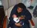 1994 Ford Crown Victoria - A man cradles a baby in his arms, looking down at the infant.