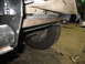 1995 Ford C-350 (Centurion Conversions) - This photo shows the underside of a vehicle, focusing on the frame and suspension system. Tools are visible on the floor.