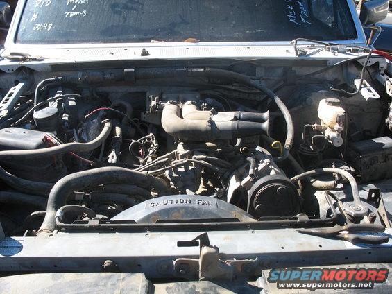 Engine bay with "CAUTION FAN" shroud visible