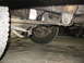 1995 Ford C-350 (Centurion Conversions) - Close-up view of the suspension system and tire of a vehicle, with visible mechanical components.