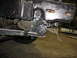 1995 Ford C-350 (Centurion Conversions) - Detail of truck frame and suspension components, likely during maintenance or modification.