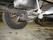1995 Ford C-350 (Centurion Conversions) - Close-up of vehicle undercarriage components, including suspension and a tire, with tools nearby.