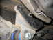 1995 Ford C-350 (Centurion Conversions) - A close-up view of a vehicle's suspension system, highlighting a black bracket and blue bushings.