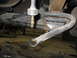 1995 Ford C-350 (Centurion Conversions) - Underside view of a vehicle's suspension system, with tools scattered on the floor.