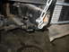 1995 Ford C-350 (Centurion Conversions) - Detail of a vehicle's suspension system, showing a chain secured to a metal bracket.