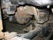 1995 Ford C-350 (Centurion Conversions) - Underside view of a vehicle's rear axle and suspension system, focusing on the differential and leaf spring mounts.