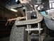 1995 Ford C-350 (Centurion Conversions) - A C-clamp is attached to a vehicle's suspension system, obscuring the exact model and year.