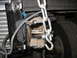 1995 Ford C-350 (Centurion Conversions) - This image shows a close-up view of a vehicle's front suspension component, possibly modified, with a heavy-duty chain secured to it.