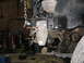 1995 Ford C-350 (Centurion Conversions) - A custom bracket is being installed on the vehicle's frame, with a chain hoist overhead.