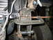1995 Ford C-350 (Centurion Conversions) - Custom suspension work is underway on a vehicle, with a C-clamp securing a modified bracket.