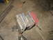 1995 Ford C-350 (Centurion Conversions) - Custom welded metal brackets, likely for a vehicle suspension modification, are shown on a workshop floor with various tools.