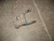 1995 Ford C-350 (Centurion Conversions) - This is a single leaf spring shackle, likely from a truck, resting on a concrete surface.