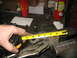 1995 Ford C-350 (Centurion Conversions) - A tape measure is used to measure a suspension component held in a vise.