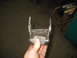 1995 Ford C-350 (Centurion Conversions) - A metal suspension component, likely a shackle, is held up for inspection.