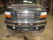 1995 Ford C-350 (Centurion Conversions) - The front grille and bumper of a dark green Ford truck are visible.